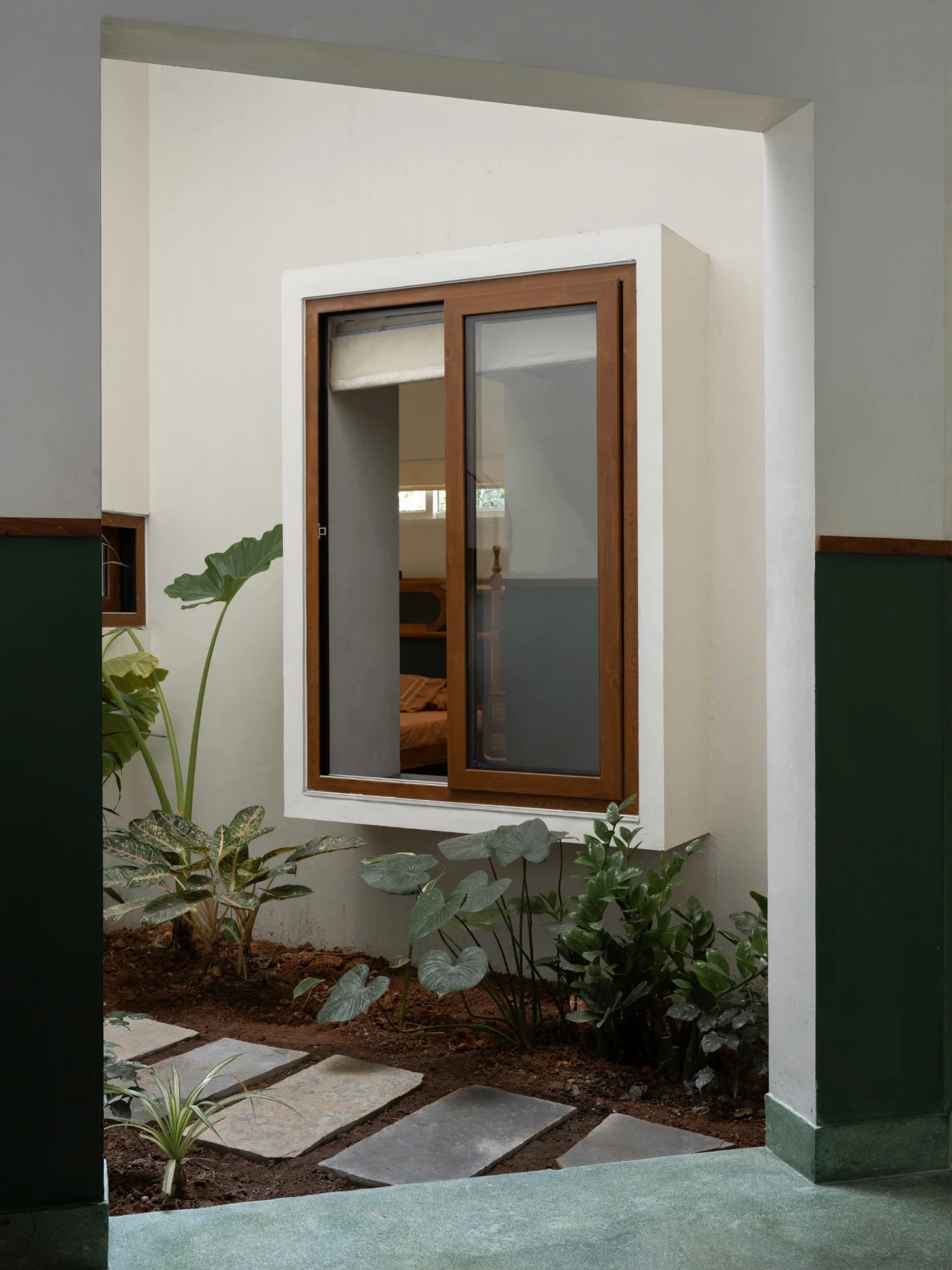 An internal garden with a teak window opening into a bedroom